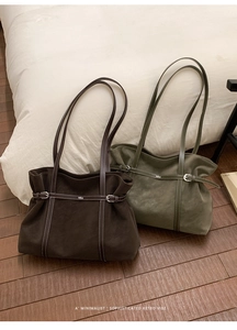 Detail of dark brown and olive green suede tote bags with white contrast stitching