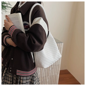Close-up of the woven texture and large capacity of this white shoulder bucket bag