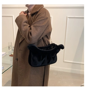 Détail du sac nuage en peluche noire avec chaîne dorée et texture plissée douce