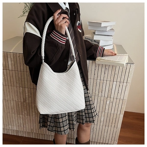 Detail of white woven hobo bucket bag texture shown in a preppy lifestyle setting