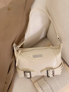 Minimalist cream beige leather underarm bag with silver hardware on a neutral background