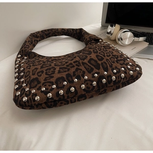 Macro shot of leopard print handbag with silver rivet details and hobo silhouette