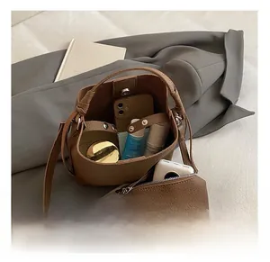 Vista interna del secchiello vintage in pelle marrone con pochette piccola coordinata
