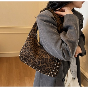 Close-up of leopard print hobo bag with metallic rivets and sleek half-moon silhouette