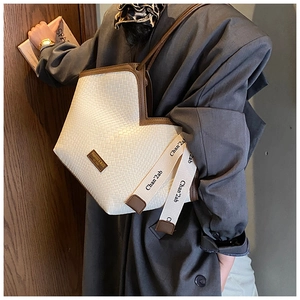Détail du sac cabas tissé avec garniture en cuir marron et ruban décoratif