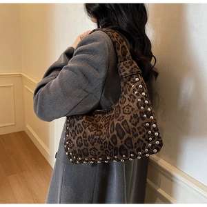 Detail view of leopard print tote bag with silver metal rivets and plush texture