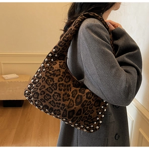 Detail of leopard print tote bag with silver studs on textured fabric and carry handle