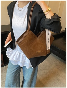Gros plan du sac cabas marron tissé avec ouverture en V et large bandoulière en tissu imprimé