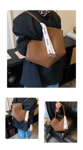 Détail d'un grand sac cabas tressé marron foncé avec bandoulière et ruban décoratif