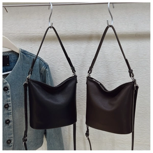 Detail der Ledertextur mit Lychee-Muster bei schwarzen und braunen Bucket-Bags