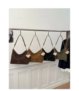 Detail of four hobo bags in coffee, caramel, black and green with teddy bear charms