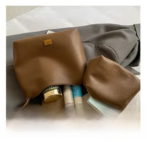 Détail de la capacité intérieure du sac seau en cuir marron avec sa pochette assortie