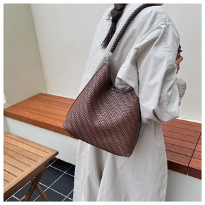 Detailed herringbone weave and metal hardware on dark brown leather shoulder bag