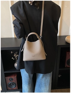 Borsa a secchiello talpa con texture litchi indossata da una modella nel quotidiano