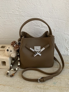 Brown lychee leather bucket bag with silver cross lock, shoulder strap and plush dog charm