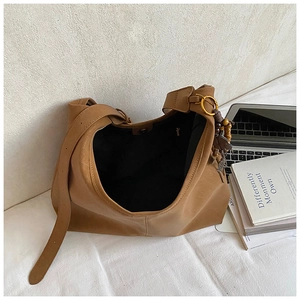 Detail of camel oversized tote bag with magnetic closure and wooden bead charm detail