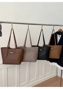Detail view of four large tote bags in lychee leather with golden metal twist locks
