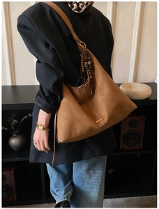 Brown vintage hobo tote bag with wooden bead tassel shown in a classic retro interior