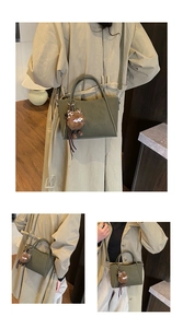 Detail of dark green matte suede bucket bag with cute brown plush keychain accessory