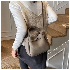 Detail of grey lychee leather bucket bag featuring silver twist lock and strap
