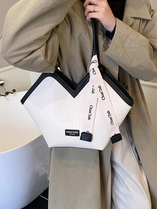 Sac cabas tissé blanc avec bordure noire et ruban en soie porté à l'épaule