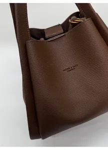 Detail of dark brown lychee leather bucket bag with MIQIER branding and sturdy handles