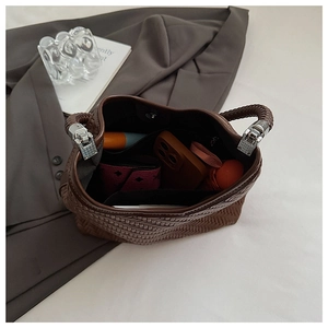 Detailed interior of large brown woven bucket bag showing ample storage space and handle
