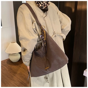 Detailed side view of a large vintage coffee brown leather tote bag with boho charm