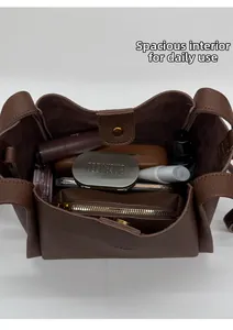 Detailed interior of brown pebbled leather bucket bag showing large capacity for daily items