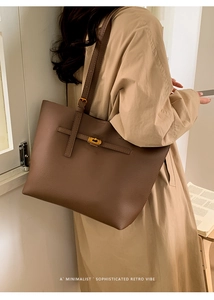 Detailed view of dark brown leather tote bag with gold lock buckle and lychee texture