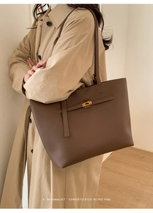 Detail of a brown leather tote bag with gold metal twist lock and minimalist retro texture