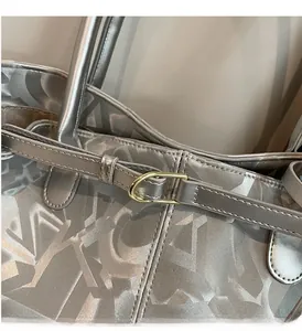 Close-up of metallic silver tote bag with geometric pattern and golden horseshoe buckle