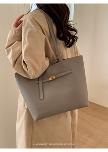 Detailed close-up of grey pebbled leather tote bag with elegant gold twist-lock closure