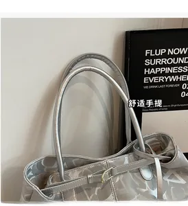 Detail of silver tote bag featuring geometric patterns, sleek handles, and metallic buckle