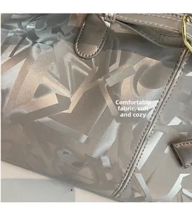 Detail of silver-grey tote bag showing soft fabric texture and abstract geometric pattern