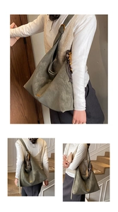 Detail van olijfgroene suède hobo tas met houten kralenkwastje en gouden gesp