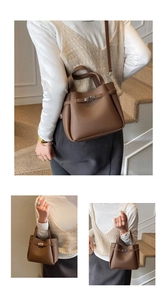 Detail view of a vintage dark brown leather bucket bag with silver lock and shoulder strap