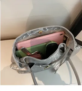 Spacious interior of silver metallic tote bag showing storage for tablet and wallet