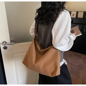Détail du grand sac cabas en cuir marron avec motifs floraux et bandoulière large