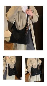 Gedetailleerd overzicht van zwarte suède shopper met kralenhanger en ruime binnenkant