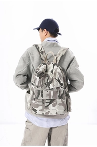 Detailansicht eines großen Camouflage-Rucksacks aus Canvas, von einem Modell getragen