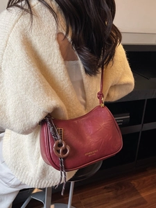 Retro burgundy leather dumpling shoulder bag with gold hardware shown on a model