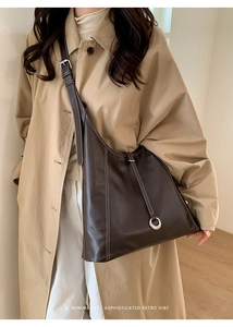 Detail of dark brown retro tote bag with white contrast stitching and silver ring hardware