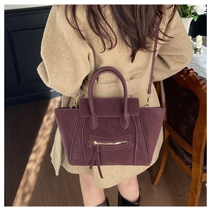 Dunkel weinrote matte Henkeltasche kombiniert mit beigem Mantel im Vintage-Stil