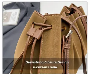 Macro detail of caramel leather bucket bag with drawstrings and white contrast stitching