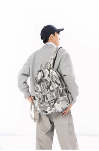 Rückansicht des Camouflage-Leinwandrucksacks, getragen von einem Modell vor Weiß