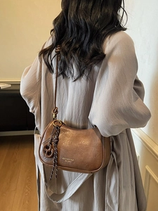 Retro brown leather half-moon shoulder bag with creative pretzel charm and long strap