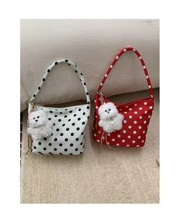 Polka dot nylon shoulder bags in black and red with cute puppy charms on soft carpet