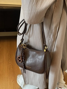 Retro dark brown crossbody dumpling bag with adjustable knotted strap and charm