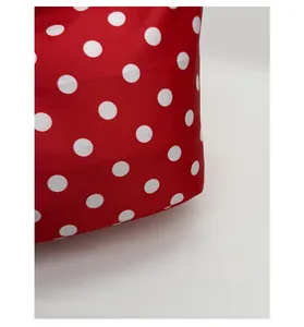 Detailed close-up of red canvas fabric with white polka dot pattern for women handbag